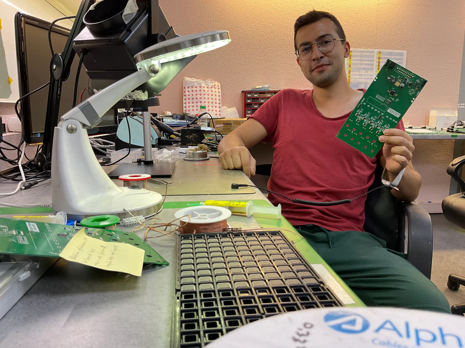 At the workbench holding a tested circuit board